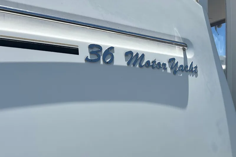 Slide: The Image of 2005 Carver 36 Motor Yacht nameplate on white hull, showcasing elegant design. - 150