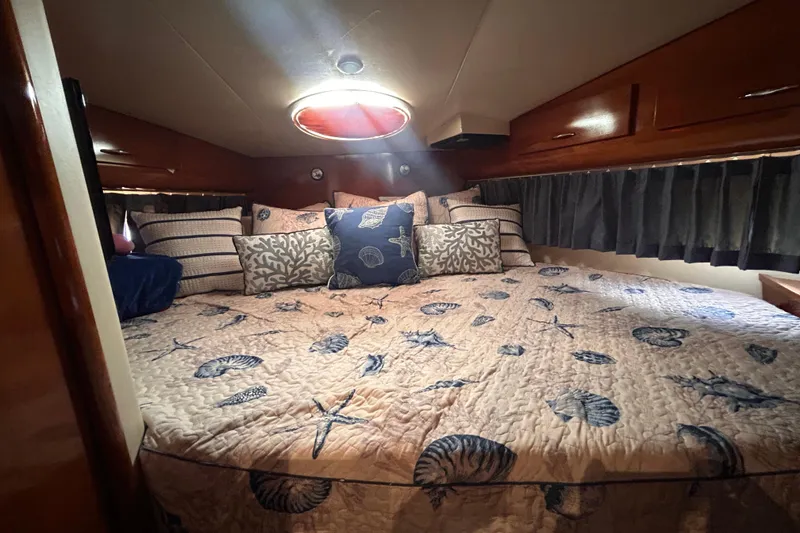 Slide: The Image of Cozy bedroom in 2005 Carver 36 Motor Yacht with nautical-themed bedding and pillows. - 97