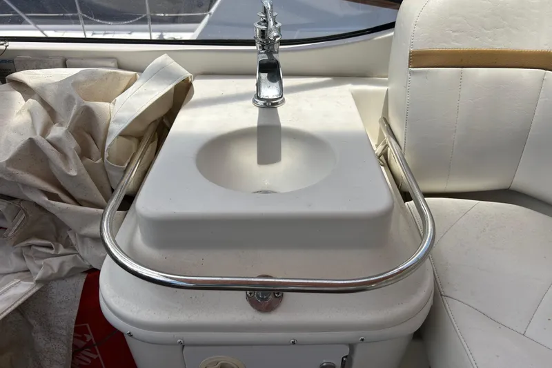 Slide: The Image of 2005 Carver 36 Motor Yacht interior sink with white seating and metal railing. - 49