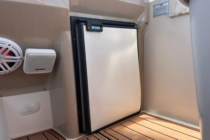 Slide: The Image of 2005 Carver 36 Motor Yacht interior with fridge and speakers on teak flooring. - 50