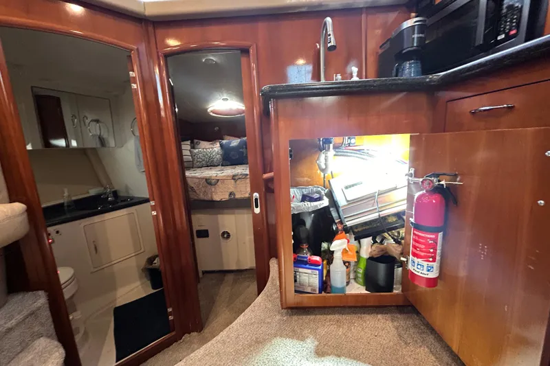 Slide: The Image of 2005 Carver 36 Motor Yacht interior with kitchenette, storage, and cozy sleeping area. - 86