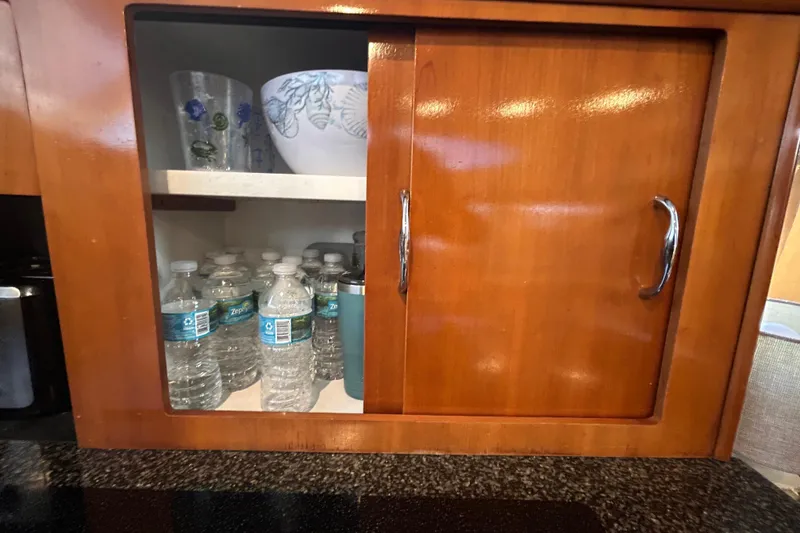 Slide: The Image of Wooden cabinet in 2005 Carver 36 Motor Yacht, storing water bottles and glassware. - 84