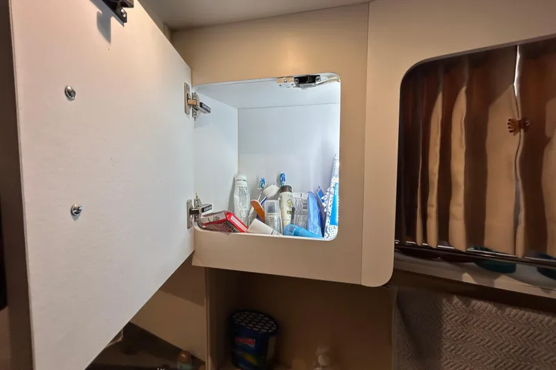 Slide: The Image of Open cabinet in 2005 Carver 36 Motor Yacht bathroom, displaying toiletries and essentials. - 127