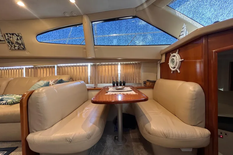 Slide: The Image of Interior of 2005 Carver 36 Motor Yacht with plush seating and wooden table. - 90