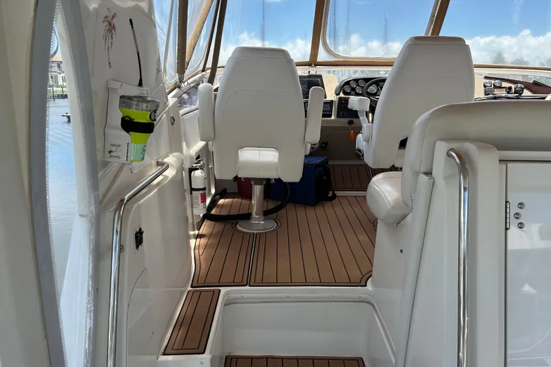 Slide: The Image of Interior view of 2005 Carver 36 Motor Yacht cockpit with white seating and wooden flooring. - 23
