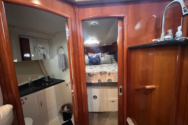 Slide: The Image of Interior of 2005 Carver 36 Motor Yacht featuring bedroom and bathroom with wooden finishes. - 94