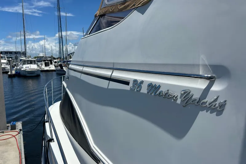 Slide: The Image of 2005 Carver 36 Motor Yacht docked at a marina under a clear blue sky. - 149