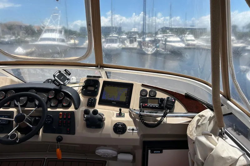Slide: The Image of Helm of 2005 Carver 36 Motor Yacht with navigation equipment and marina view. - 38