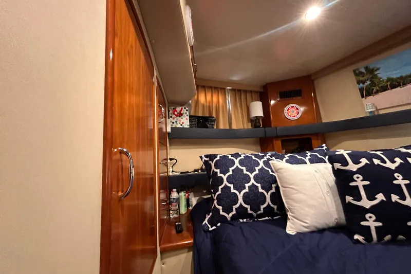 Slide: The Image of Cozy interior of 2005 Carver 36 Motor Yacht with nautical-themed bedding and wooden cabinetry. - 121