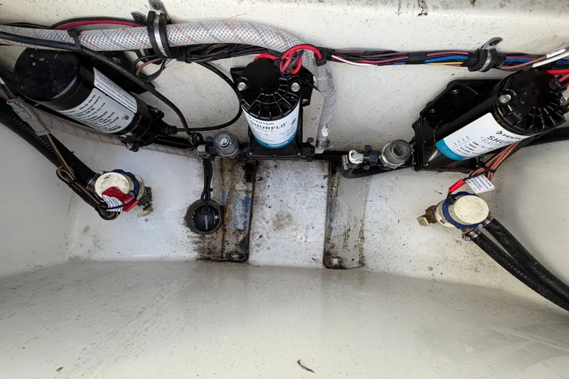Slide: The Image of Interior view of 2025 Sea Hunt Gamefish 27CB boat wiring and pumps. - 62