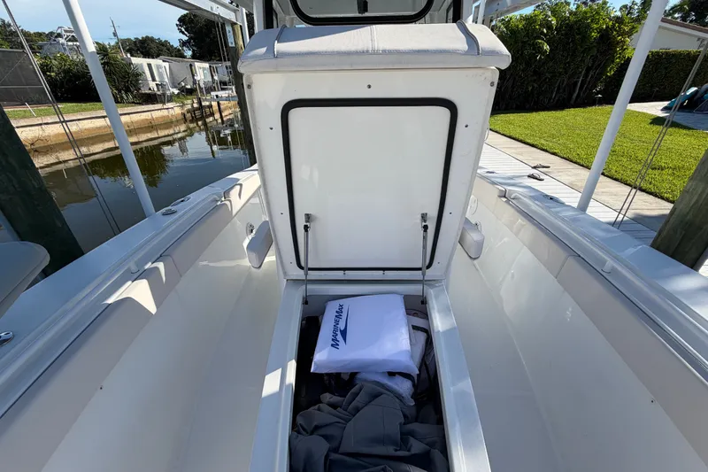 Slide: The Image of 2025 Sea Hunt Gamefish 27CB boat interior storage compartment open by the dock. - 52