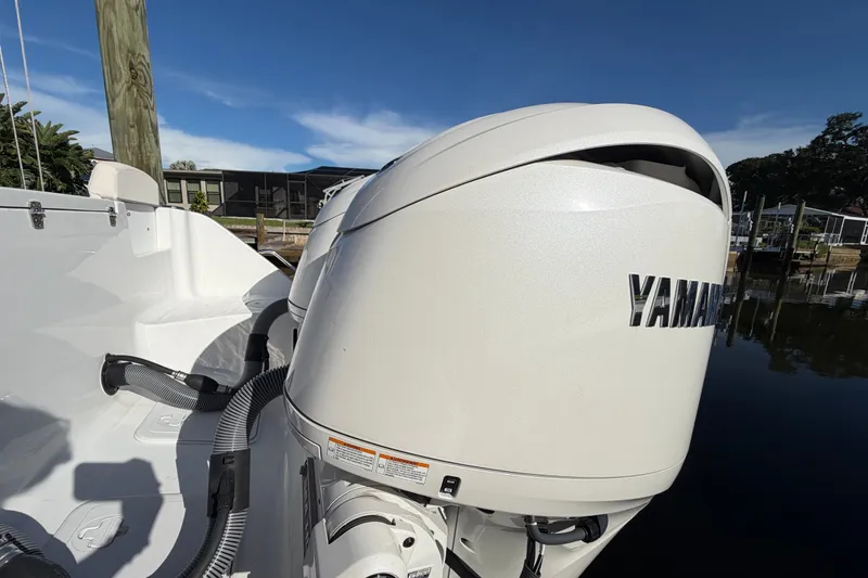 Slide: The Image of 2025 Sea Hunt Gamefish 27CB with Yamaha outboard engine, docked by the water. - 76