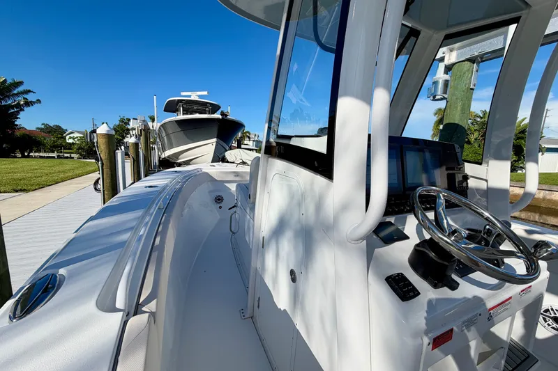 Slide: The Image of 2025 Sea Hunt Gamefish 27CB boat docked, showcasing steering console and sleek design. - 38