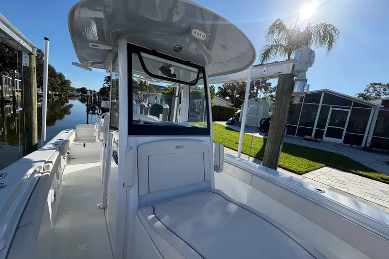 Slide: The Image of 2025 Sea Hunt Gamefish 27CB boat docked by a canal under clear blue sky. - 55