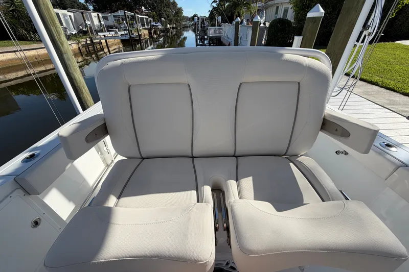 Slide: The Image of 2025 Sea Hunt Gamefish 27CB boat seating, featuring comfortable, cushioned design by a serene dock. - 56
