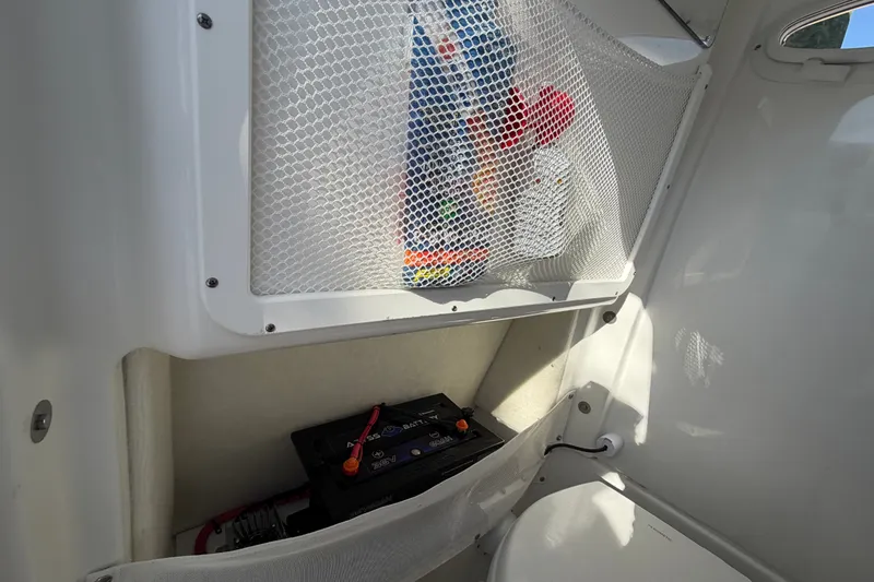 Slide: The Image of Battery compartment of 2025 Sea Hunt Gamefish 27CB boat with storage netting. - 43