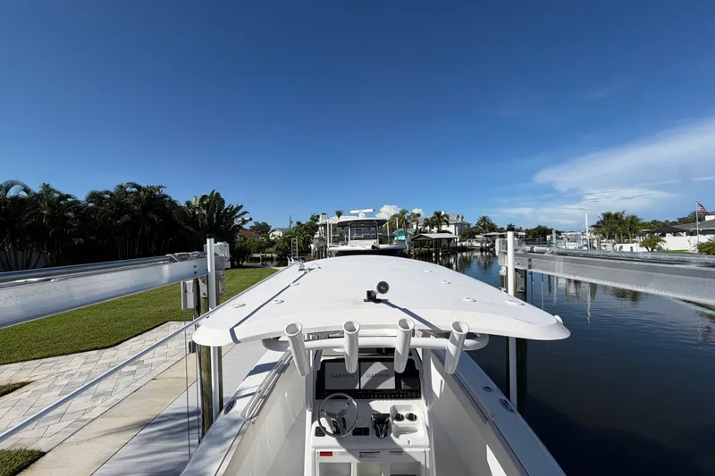Slide: The Image of 2025 Sea Hunt Gamefish 27CB boat docked in a scenic canal setting. - 78