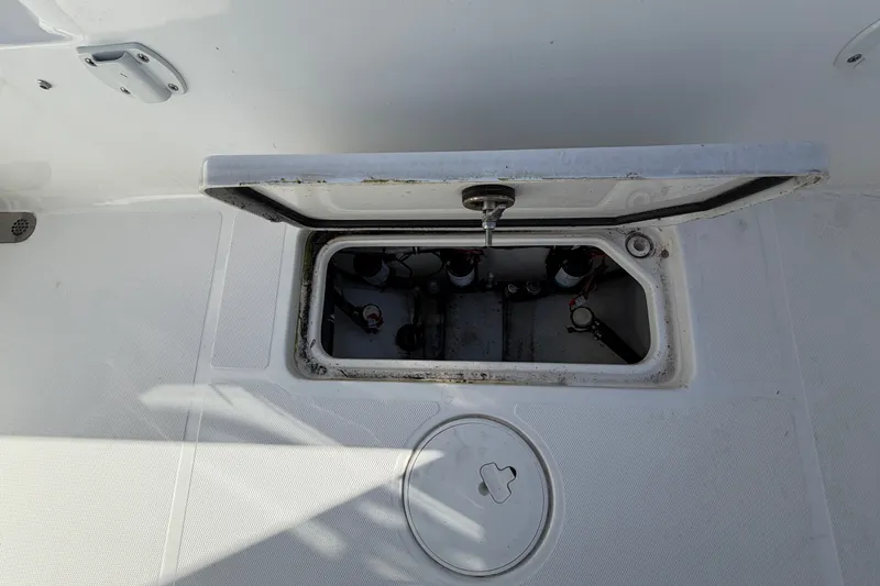 Slide: The Image of Open hatch on 2025 Sea Hunt Gamefish 27CB boat deck, revealing internal compartment. - 61