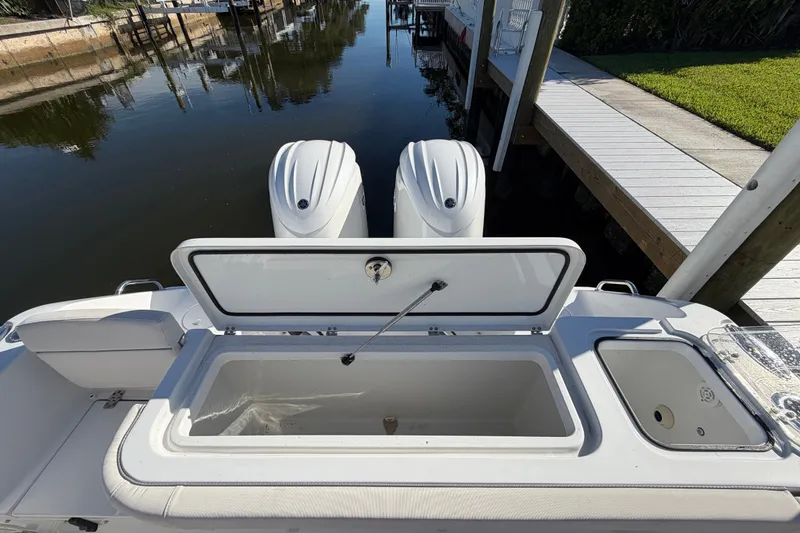 Slide: The Image of 2025 Sea Hunt Gamefish 27CB boat with open storage compartment and dual engines. - 67