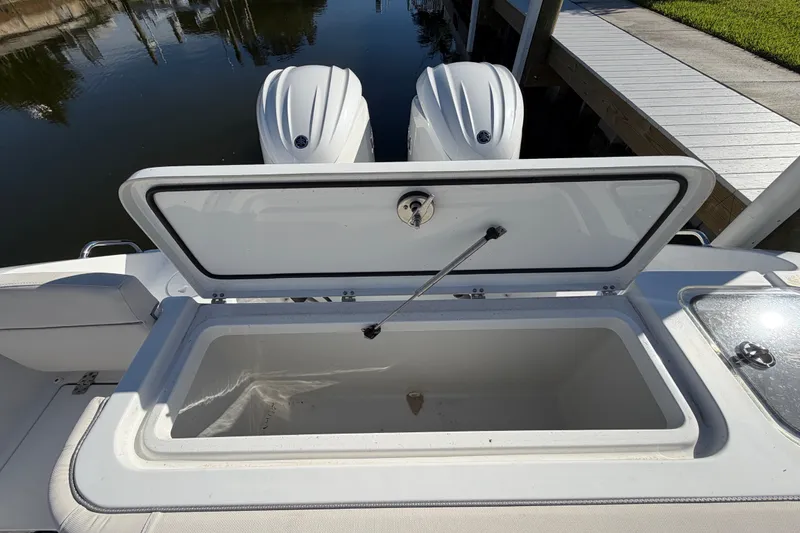 Slide: The Image of 2025 Sea Hunt Gamefish 27CB boat with open storage compartment and twin engines. - 69
