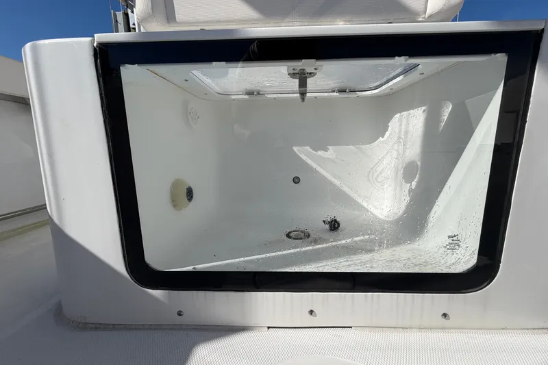 Slide: The Image of Livewell compartment on a 2025 Sea Hunt Gamefish 27CB boat, featuring a clear lid. - 13