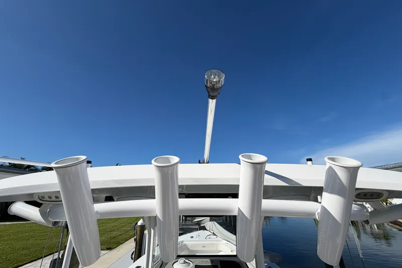 Slide: The Image of 2025 Sea Hunt Gamefish 27CB boat with rod holders under clear blue sky. - 79