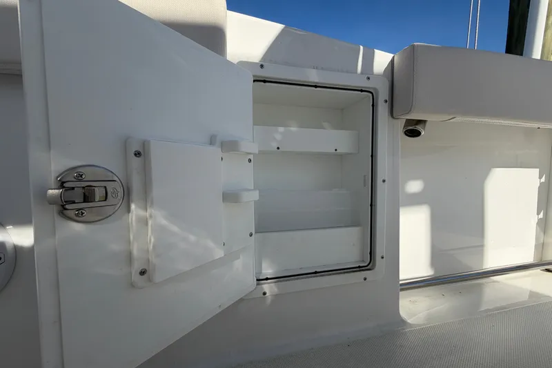 Slide: The Image of Open storage compartment on 2025 Sea Hunt Gamefish 27CB boat, featuring secure latch. - 66