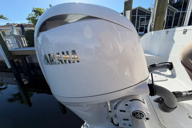 Slide: The Image of 2025 Sea Hunt Gamefish 27CB with Yamaha outboard engine, docked near waterfront homes. - 75