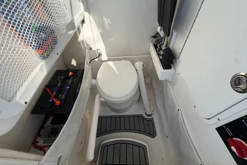 Slide: The Image of 2025 Sea Hunt Gamefish 27CB boat interior with toilet and battery compartment. - 41