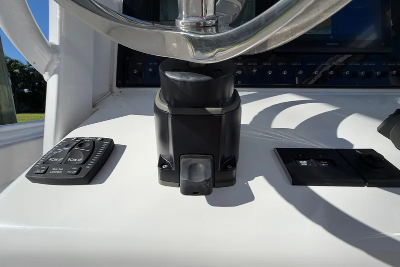 Slide: The Image of Control panel of 2025 Sea Hunt Gamefish 27CB boat, featuring steering wheel and switches. - 35