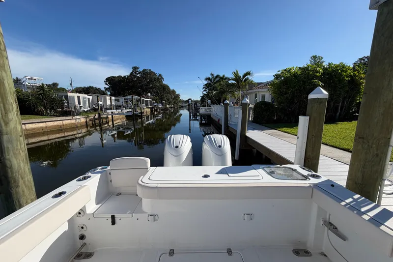 Slide: The Image of 2025 Sea Hunt Gamefish 27CB docked in a serene canal setting. - 63