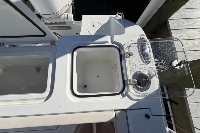Slide: The Image of 2025 Sea Hunt Gamefish 27CB boat deck with storage compartments and fishing rod holders. - 70