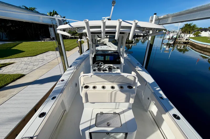 Slide: The Image of 2025 Sea Hunt Gamefish 27CB boat docked by a serene waterfront. - 14