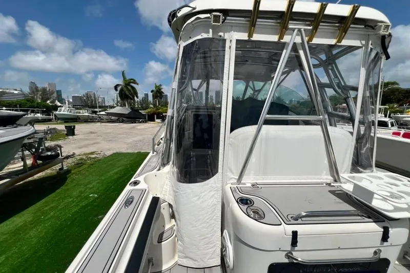 Slide: The Image of Een Hydra-Sports 3300 VX uit 2005 met ruime cockpit en helder afdak, geparkeerd aan een steiger. - 34