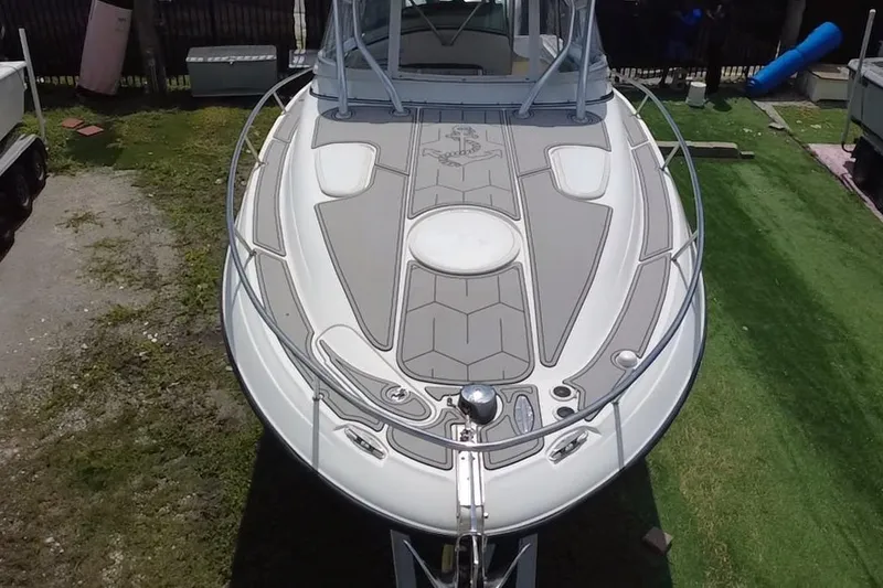 Slide: The Image of Een Hydra-Sports 3300 VX boot uit 2005 met een ruim voordek en slanke lijnen, geparkeerd op gras. - 7