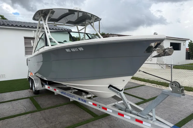 Slide: The Image of 2021 Cobia 240 Dual Console boat on trailer, parked in residential driveway. - 15