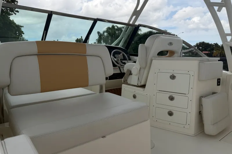 Slide: The Image of 2021 Cobia 240 Dual Console boat interior with white seating and storage drawers. - 23