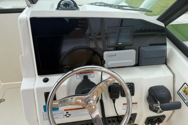 Slide: The Image of 2021 Cobia 240 Dual Console boat dashboard with Garmin navigation system and steering wheel. - 29