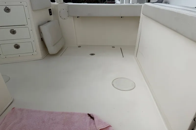 Slide: The Image of Interior of a 2021 Cobia 240 Dual Console boat, featuring storage compartments and seating. - 22