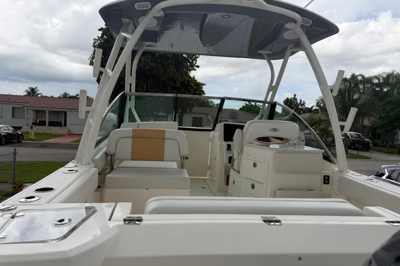 Slide: The Image of 2021 Cobia 240 Dual Console boat with seating and storage, parked in a residential area. - 21