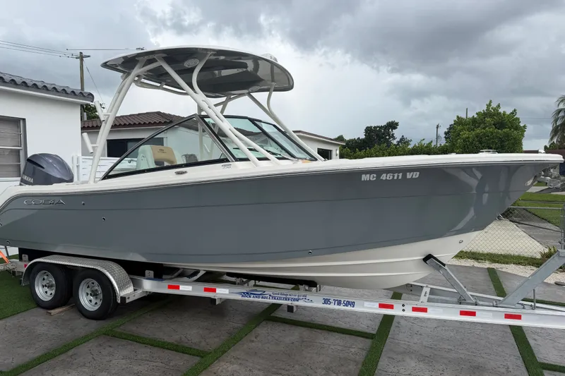 Slide: The Image of 2021 Cobia 240 Dual Console boat on trailer, parked outdoors. - 26