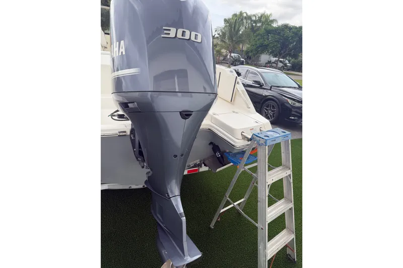 Slide: The Image of 2021 Cobia 240 Dual Console with Yamaha 300 engine and ladder on grass. - 20