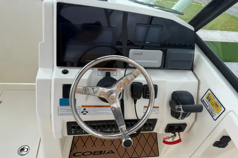 Slide: The Image of Helm of 2021 Cobia 240 Dual Console with Garmin electronics and steering wheel. - 30