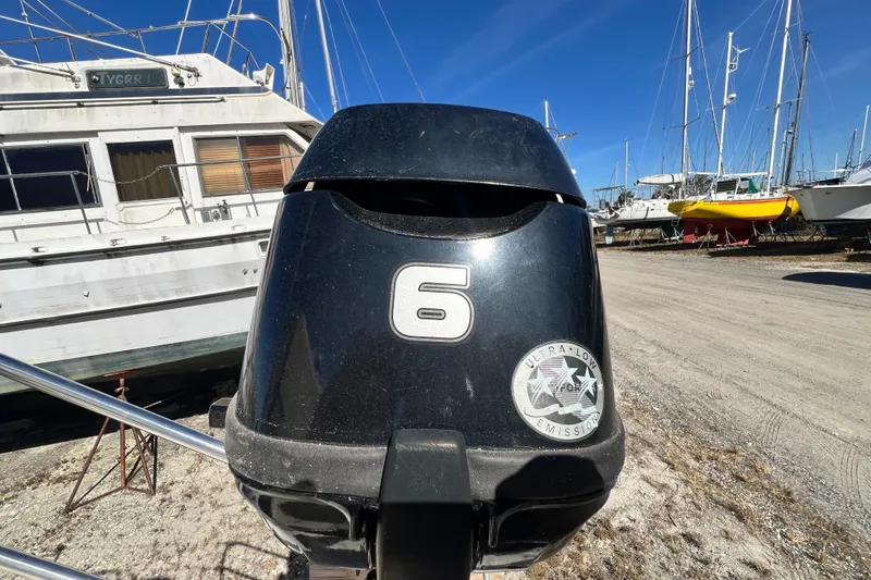 Slide: The Image of Outboard motor with ultra-low emission label near Gemini Legacy 35, 2013 model, in boatyard. - 82