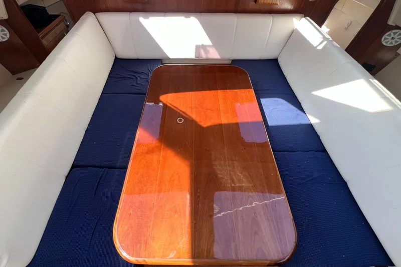 Slide: The Image of Interior of 2013 Gemini Legacy 35 with wooden table and white seating. - 86