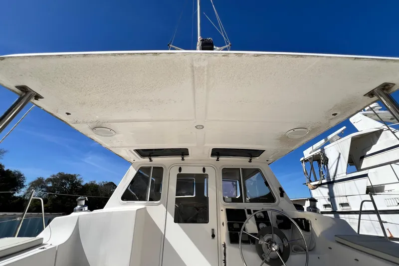 Slide: The Image of 2013 Gemini Legacy 35 catamaran cockpit with steering wheel, under clear blue sky. - 64