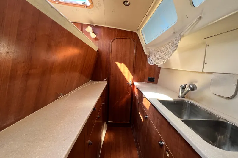 Slide: The Image of 2013 Gemini Legacy 35 yacht interior kitchen with wood cabinetry and dual sinks. - 103