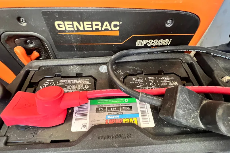 Slide: The Image of Generac GP3300i generator with battery connections, featuring red and black cables. - 142