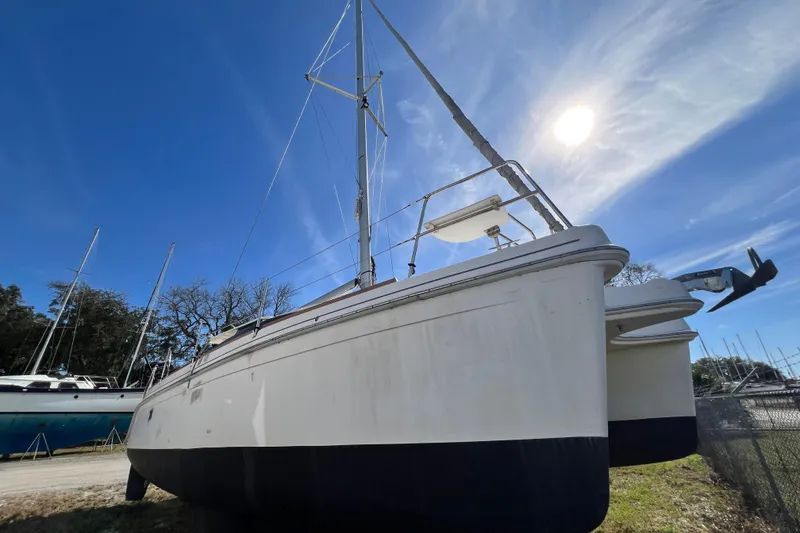 Slide: The Image of 2013 Gemini Legacy 35 catamaran on land under clear blue sky. - 21