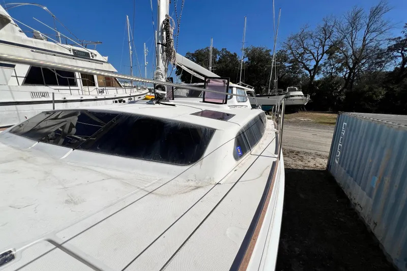 Slide: The Image of 2013 Gemini Legacy 35 catamaran docked, surrounded by other boats and trees. - 54